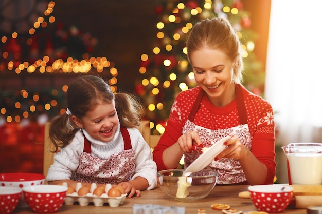 Heureuse mère et enfant drôles préparent des biscuits de noël