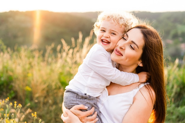 Heureuse mère étreignant son fils au coucher du soleil