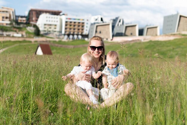 Heureuse mère étreignant son jumeau dans le parc naturel