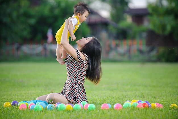 Heureuse mère de famille et bébé jouant dans le greensward