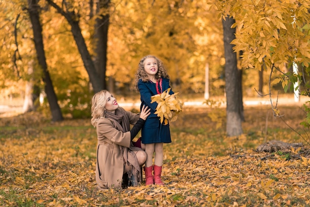 Heureuse mère de famille et fille enfant sur promenade d'automne