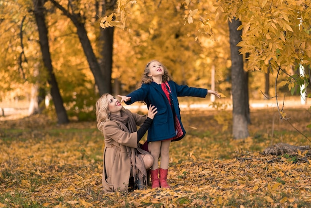 Heureuse mère de famille et fille enfant sur promenade d'automne