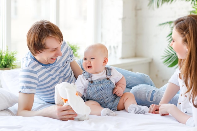 Heureuse mère de famille père et bébé fils au lit