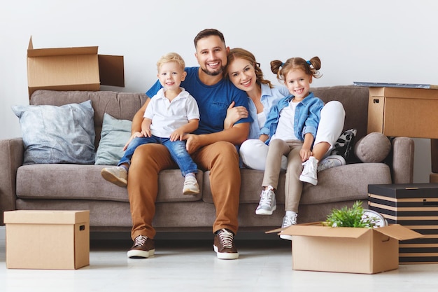 Heureuse mère de famille père et enfants déménagent dans un nouvel appartement et déballent les cartons