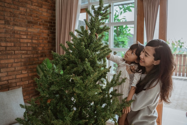 Heureuse mère et fille asiatique décorant le sapin de Noël