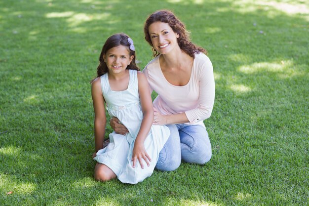 Heureuse mère et fille assise sur l&#39;herbe