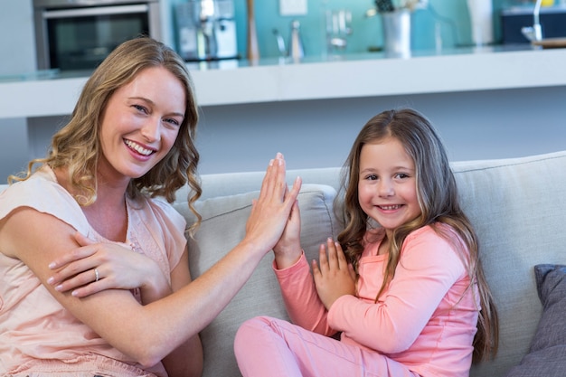 Heureuse mère et fille sur le canapé