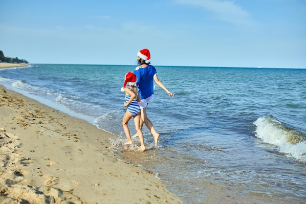 Heureuse mère et fille dans les chapeaux de Noël du Père Noël s'amusant