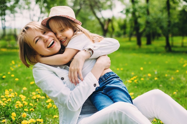 heureuse mère et fille dans le parc sur la pelouse verte