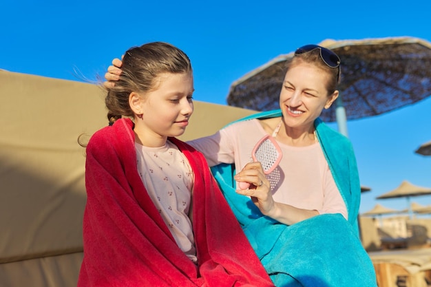 Heureuse mère et fille enfant s'amusant sur la plage