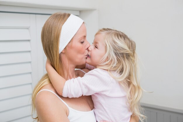 Heureuse Mère Et Fille étreignant à La Maison Dans La Salle De Bain