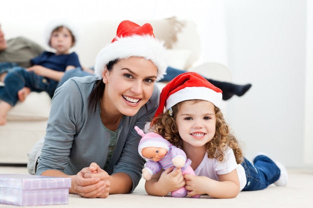 Heureuse mère et fille à Noël allongé sur le sol