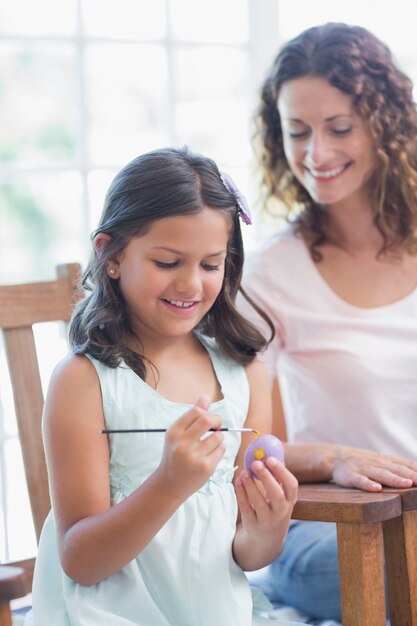 Heureuse mère et fille peignant des oeufs de Pâques