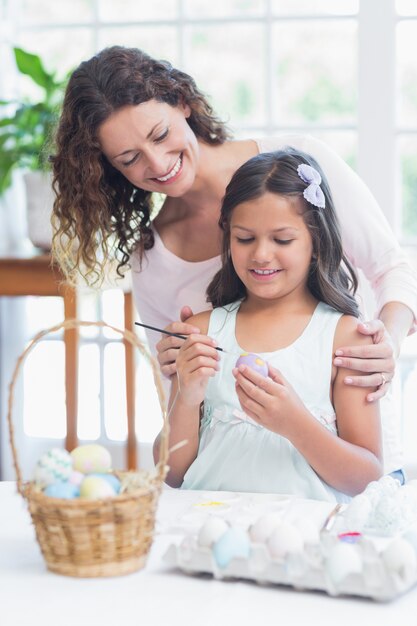 Heureuse mère et fille peignant des oeufs de Pâques