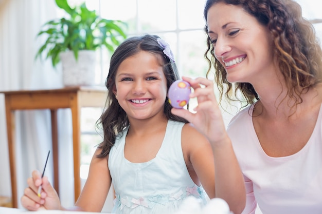 Heureuse mère et fille peignant des oeufs de Pâques