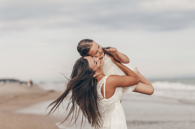 Heureuse mère et fille profitant d'une journée ensoleillée sur la plage