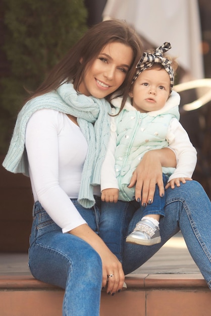 Heureuse mère et fille s'amusent et portent des vêtements en jean dans un look familial de style urbain