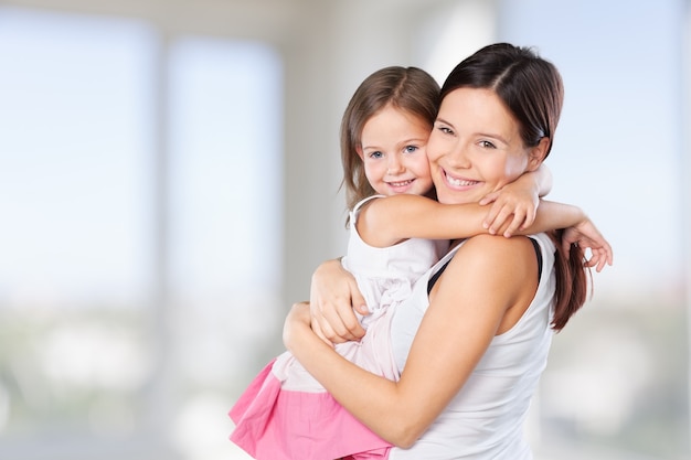 Heureuse mère et fille s'embrassant sur fond de pièce floue