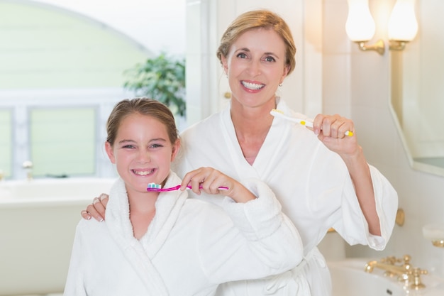 Heureuse mère et fille se brosser les dents ensemble