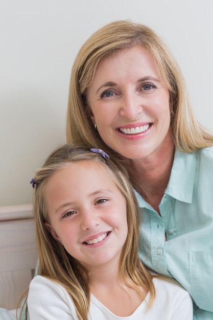 Heureuse mère et fille, souriant à la caméra