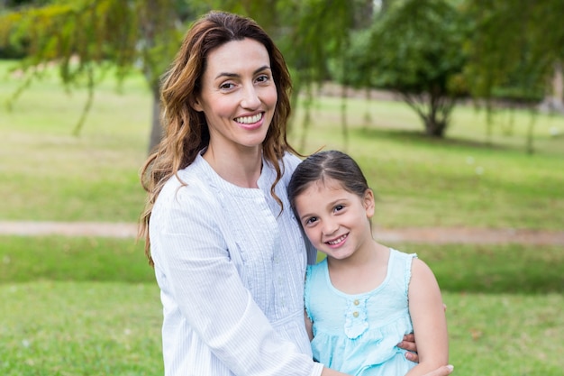 Heureuse mère et fille, souriant à la caméra