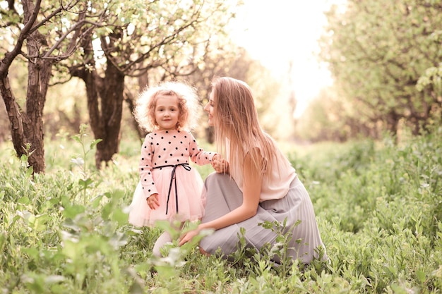 Heureuse mère avec une fille souriante qui pose à l'extérieur