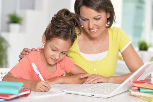 Heureuse mère et fille utilisant un ordinateur portable ensemble