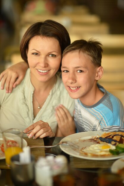Heureuse mère et fils au petit déjeuner sur la table