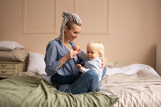 Heureuse Mère Et Fils Jouant Et Câlins à La Maison. Famille Se Détendre Sur Le Lit