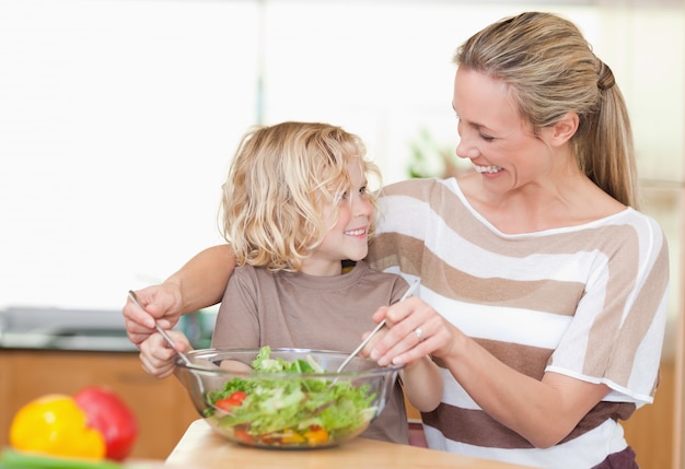 Heureuse mère et fils préparant la salade