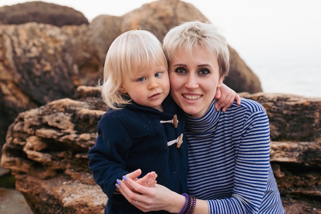 Heureuse mère et fils près de la mer au bord de la mer en automne