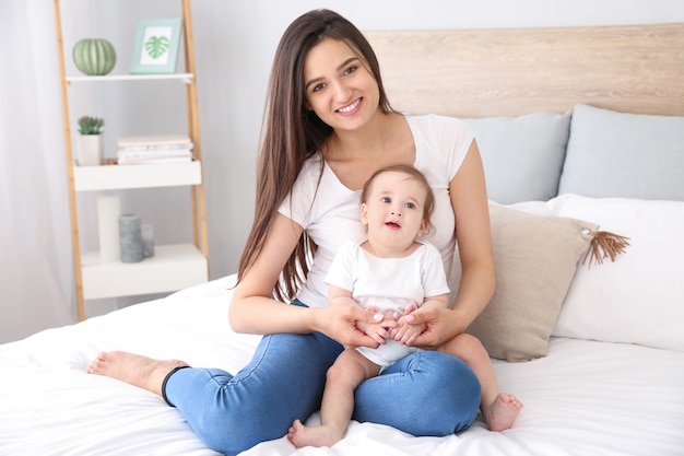 Heureuse mère avec mignon petit bébé à la maison