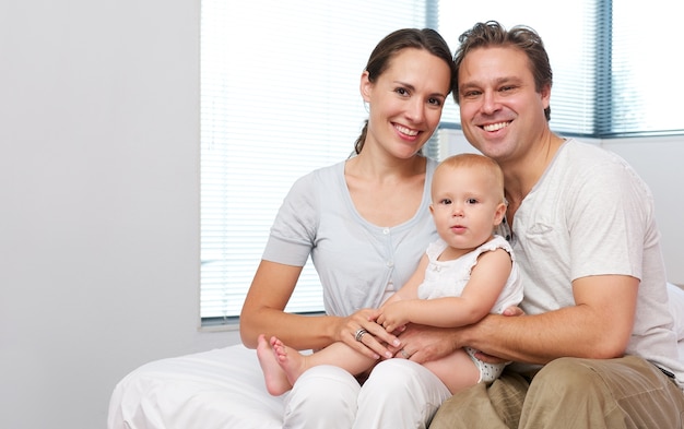 Heureuse mère et père assis à la maison avec bébé mignon