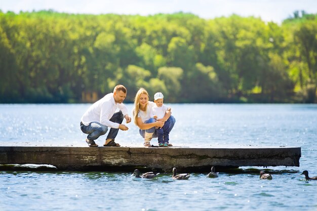 Photo heureuse mère, père et fils lors d'une promenade par une journée ensoleillée