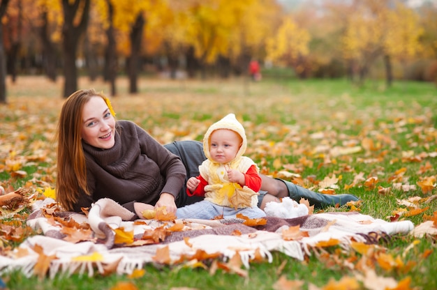 Heureuse mère et petite fille jouent dans le parc en automne.