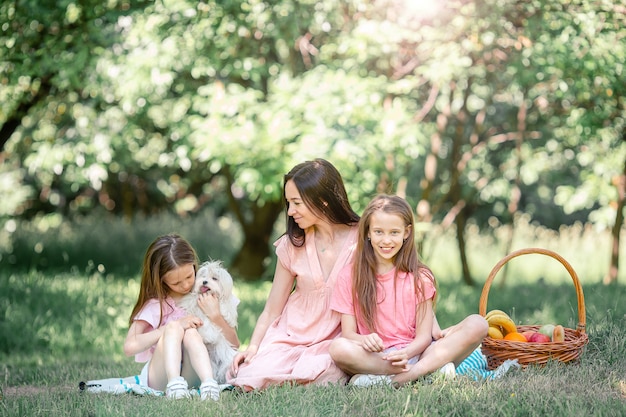 Heureuse mère et petites filles se détendre au bord du lac