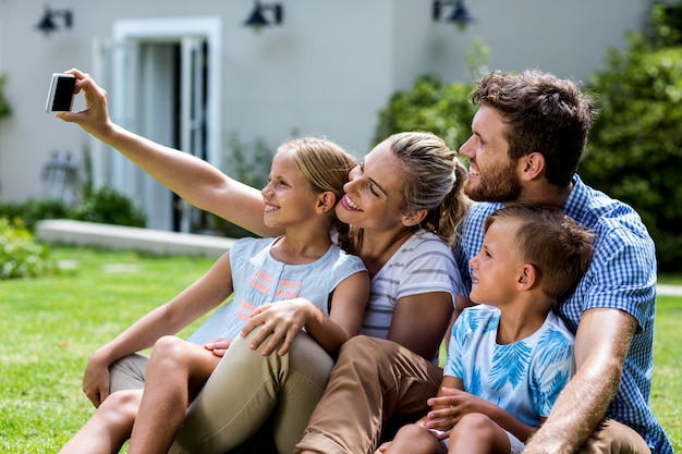 Heureuse mère prenant selfie avec famille en cour