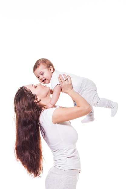 Heureuse mère remet son bébé sur le fond blanc