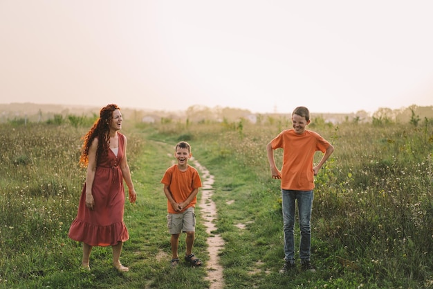 Heureuse mère s'amusant avec ses deux fils à l'extérieur Concept de famille et d'amour Concept de la relation de la fête des mères avec les adolescents soins et amour