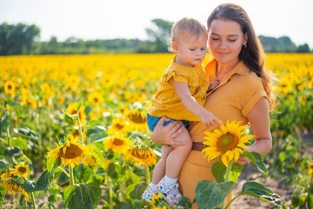 Heureuse mère et sa petite fille dans le champ de tournesol