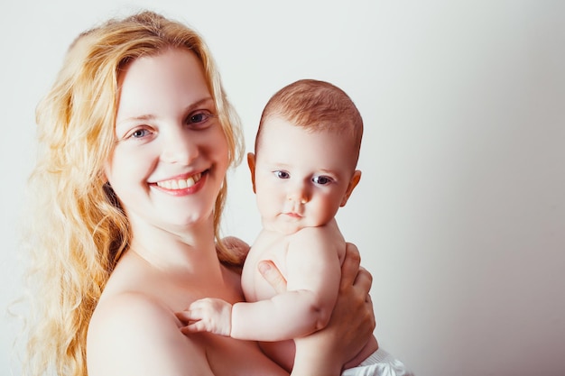 Heureuse mère avec son bébé sur blanc. Concept de maternité et de maternité