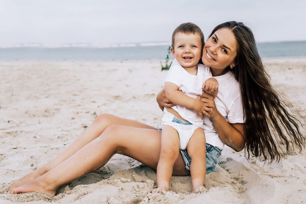 Heureuse mère avec son bébé sur la plage