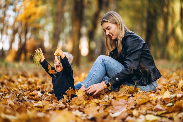 Heureuse mère avec son petit bébé s'amuser dans le parc de la ville