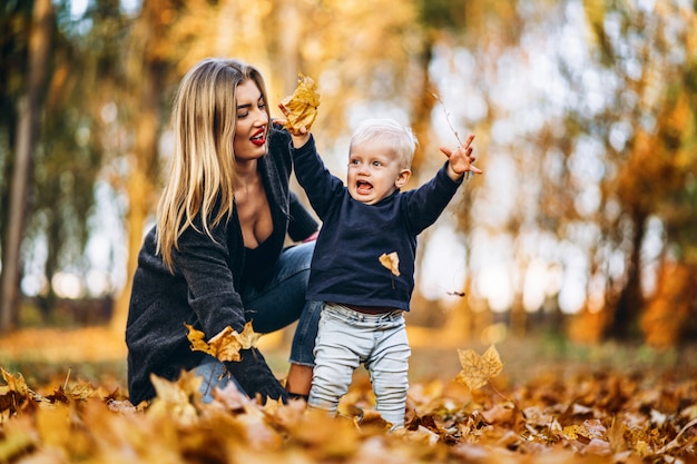 Heureuse mère avec son petit bébé s'amuser dans le parc de la ville