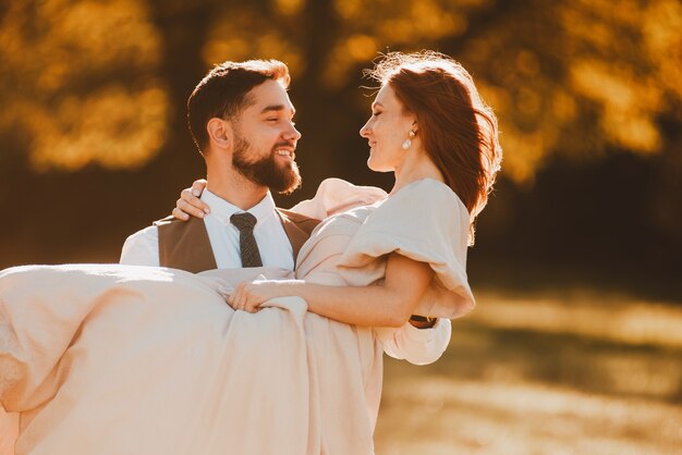 Heureuse nouvelle famille, marié tenant la mariée dans les bras