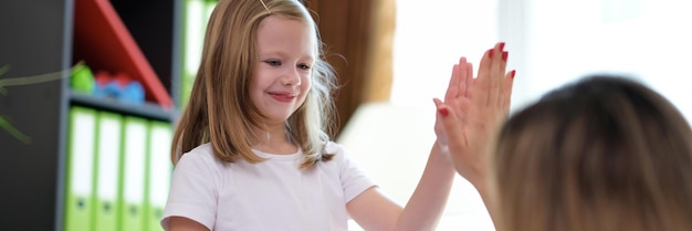 Heureuse petite fille d'âge préscolaire donnant un high five au médecin lors d'une réunion réussie à l'hôpital