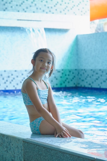 Heureuse petite fille asiatique à la piscine