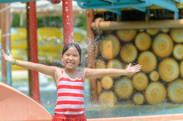 Heureuse Petite Fille Caucasienne Jouant De L'eau Au Parc Aquatique