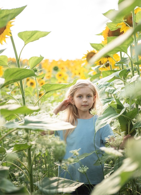 Heureuse petite fille sur le champ de tournesols en été.