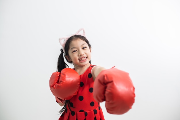 Heureuse petite fille drôle avec des gants de boxe rouges isolés